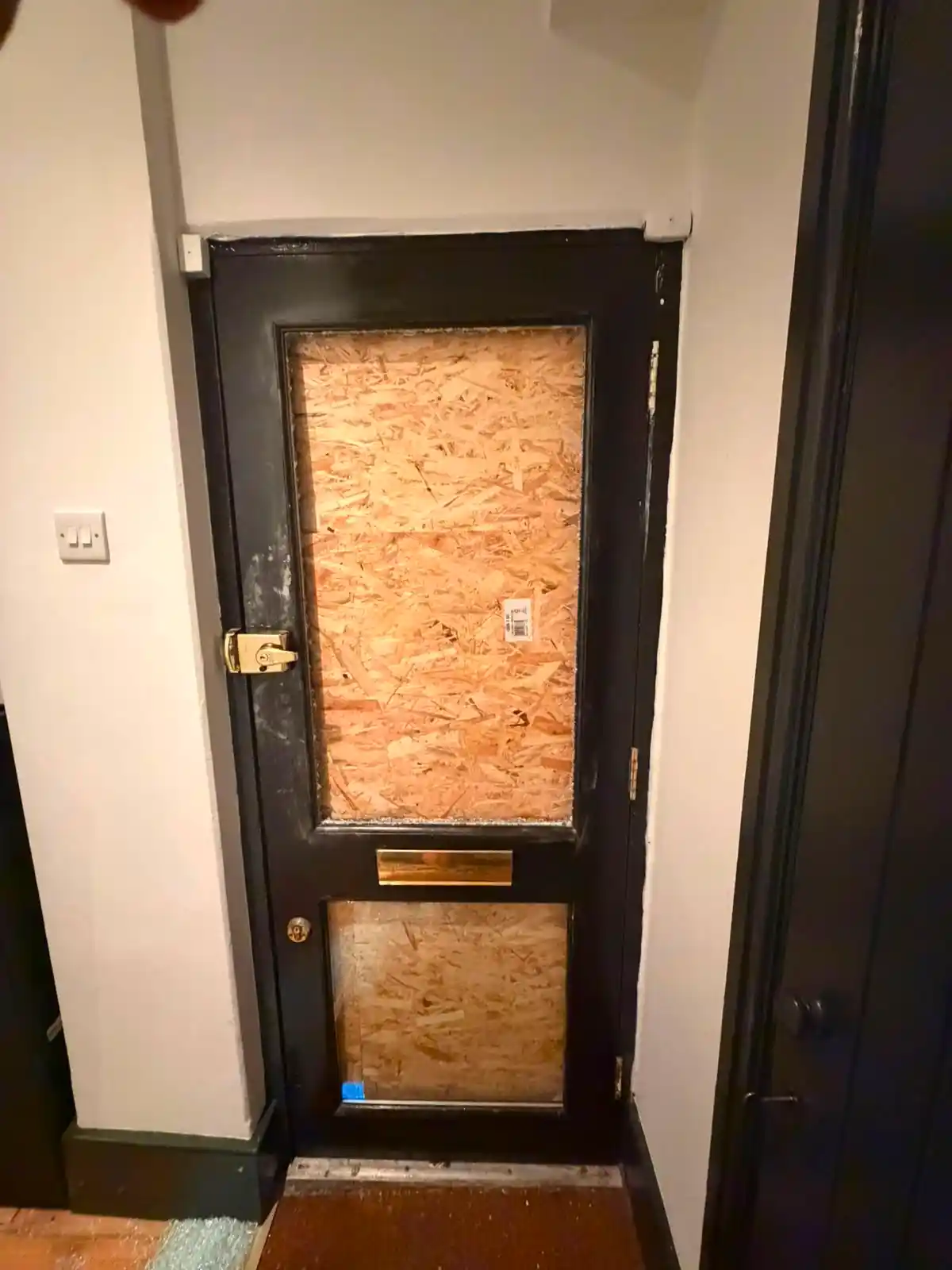 Secure temporary boarding fitted to a London front door while bespoke stained glass replacement was sourced