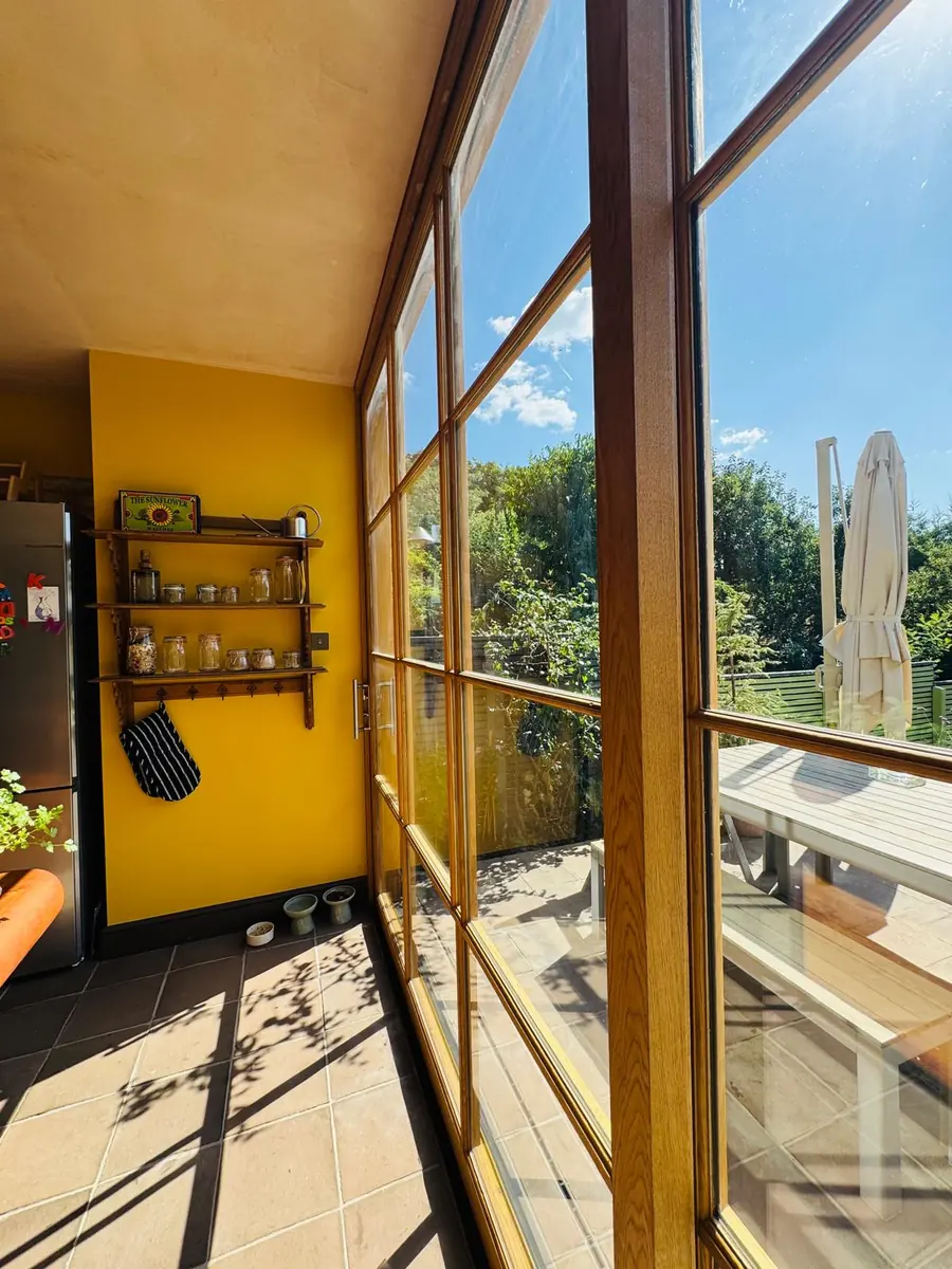 Oak sliding doors with flush sill in Islington — threshold level with the tiled floor