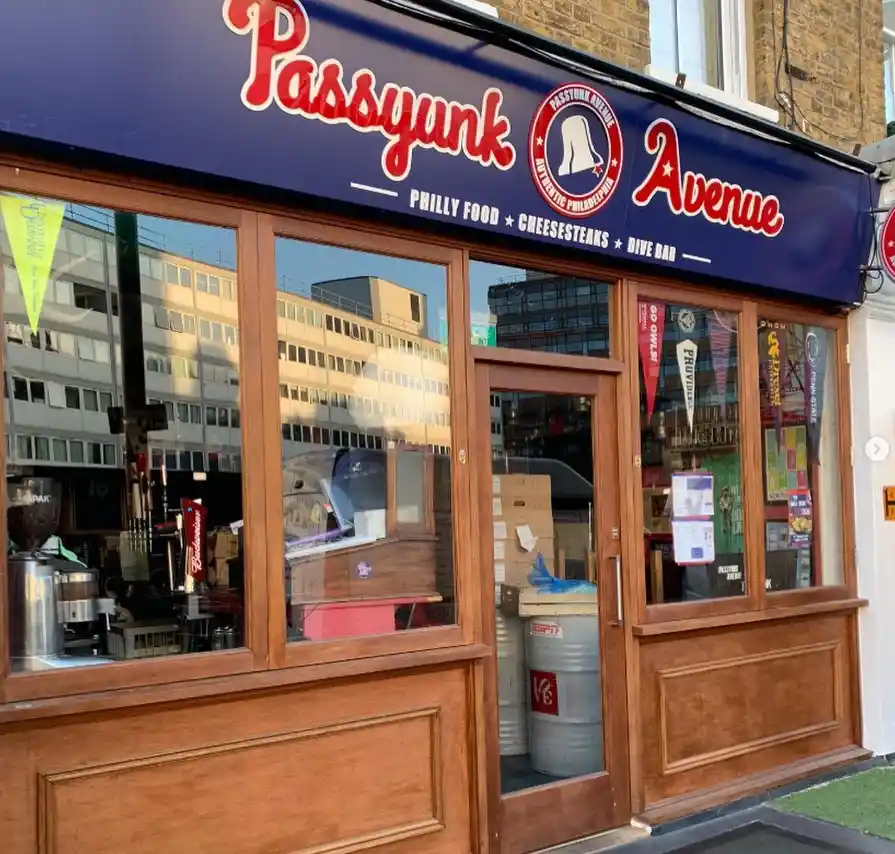 Passyunk Avenue storefront with warm timber window frames and central door design