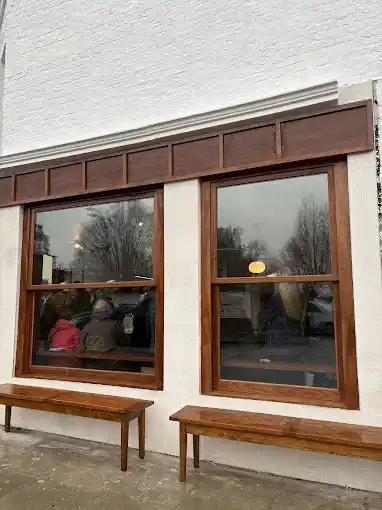 Exterior view of a commercial building with large bespoke wooden-framed shop windows