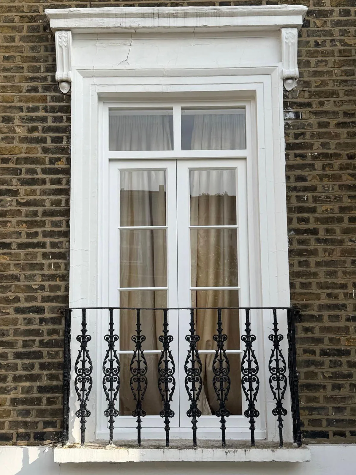 Bespoke timber French doors with fanlight and original cast iron Juliet balcony on a London townhouse